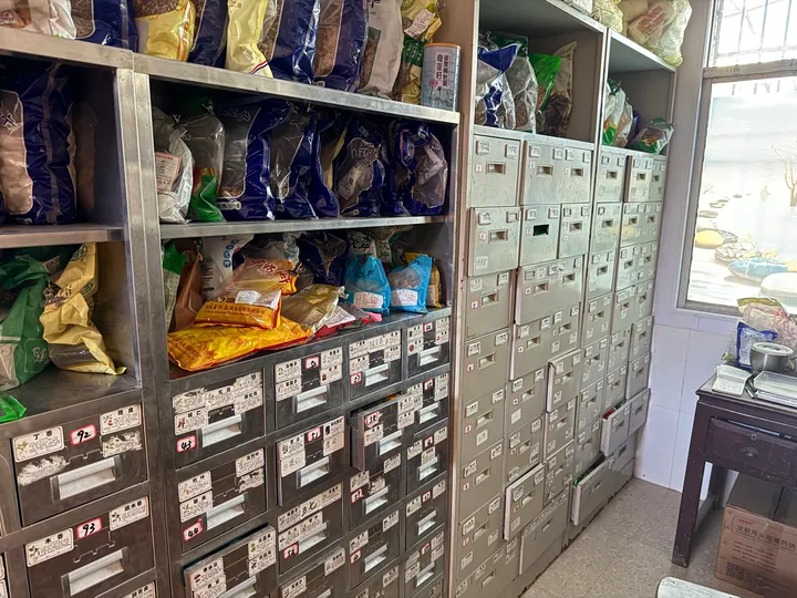 Medicine cabinets by a window, with drawers and shelves holding bagged items.