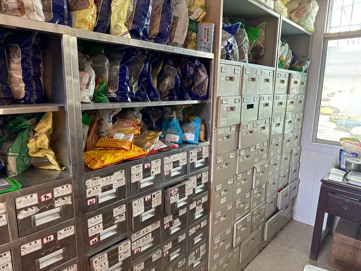 A side view of bagged items and labeled drawers in medicine cabinets.