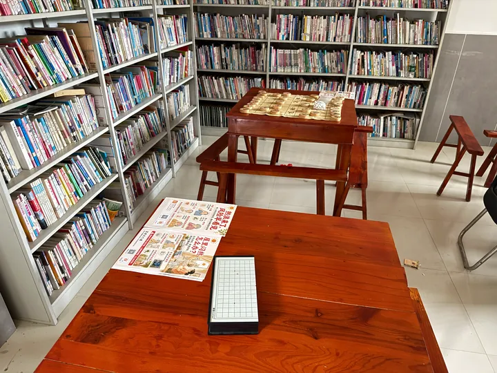 A board and heat-safety leaflets on a table beside bookshelves.