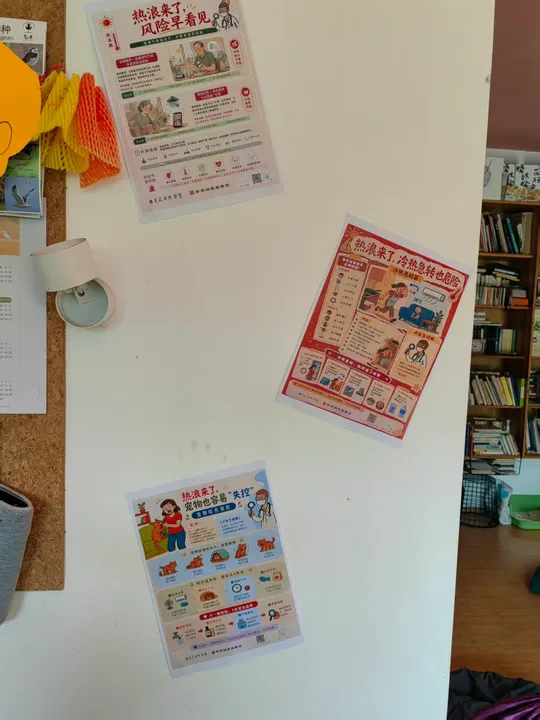 Climate and health posters displayed on a refrigerator or cabinet.