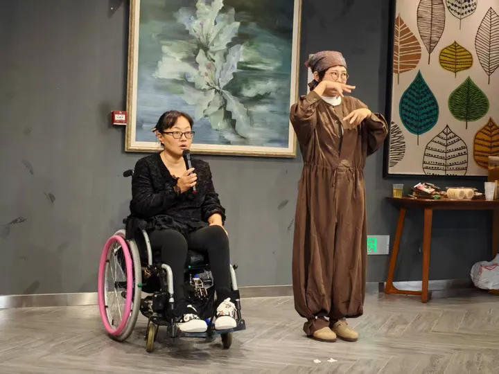 同一房间内两位参与者发言或演示；其中一人坐在轮椅上。