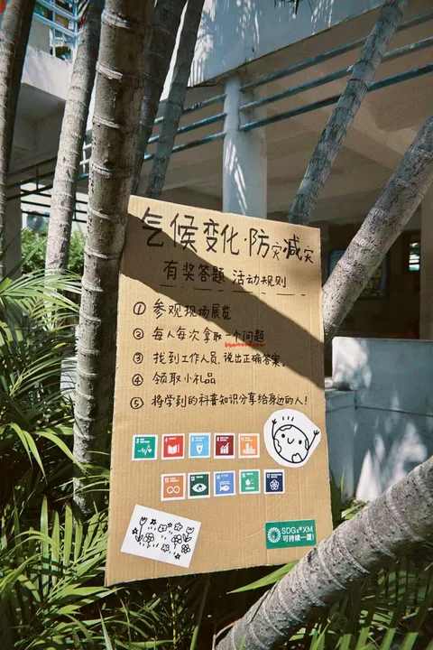 A handwritten sign for a climate and disaster-preparedness quiz beside a tree.