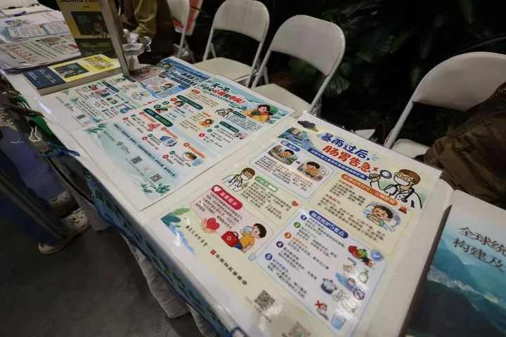 Climate and health posters laid out on a table at an indoor event.