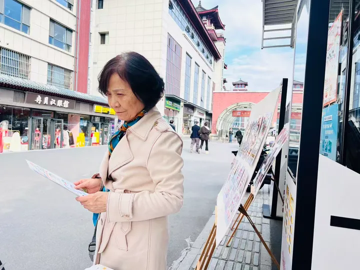 A participant reading a leaflet beside a street display.