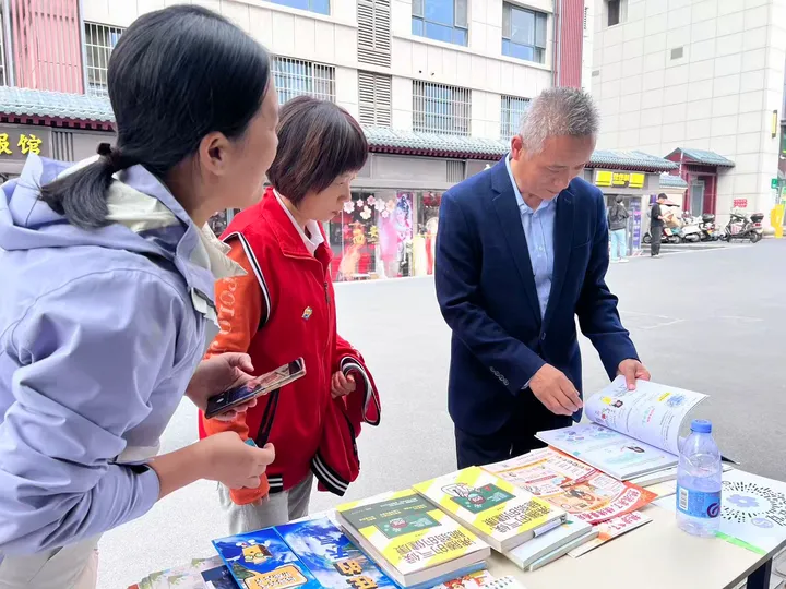 People reading and explaining climate and health materials at an outdoor table.