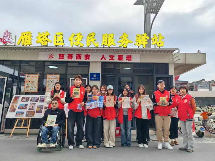 A group holding climate and health materials outside a community service station.