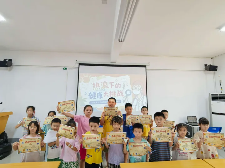 Children holding activity sheets in front of a classroom presentation about heat and health.