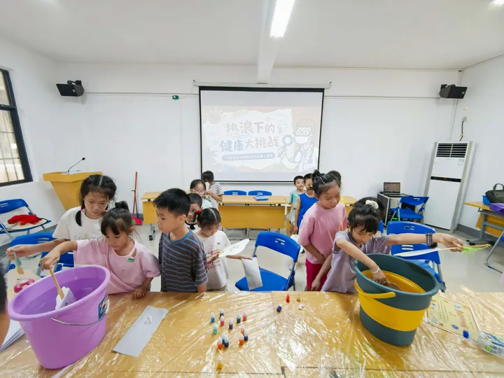 Children taking part in a tabletop activity with buckets and small objects.
