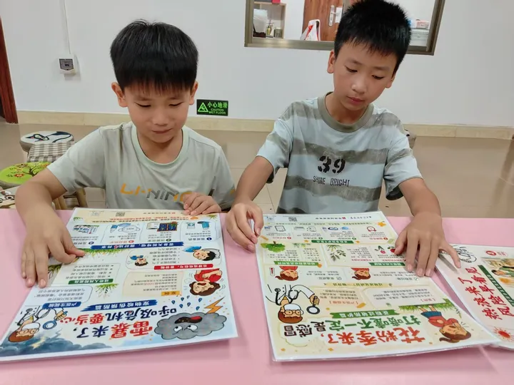 Two children reading weather and health posters.