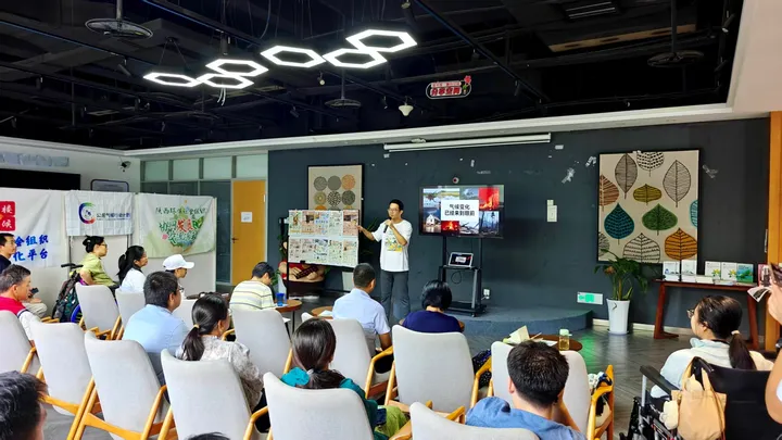 A speaker discussing climate issues with an audience in a meeting room.
